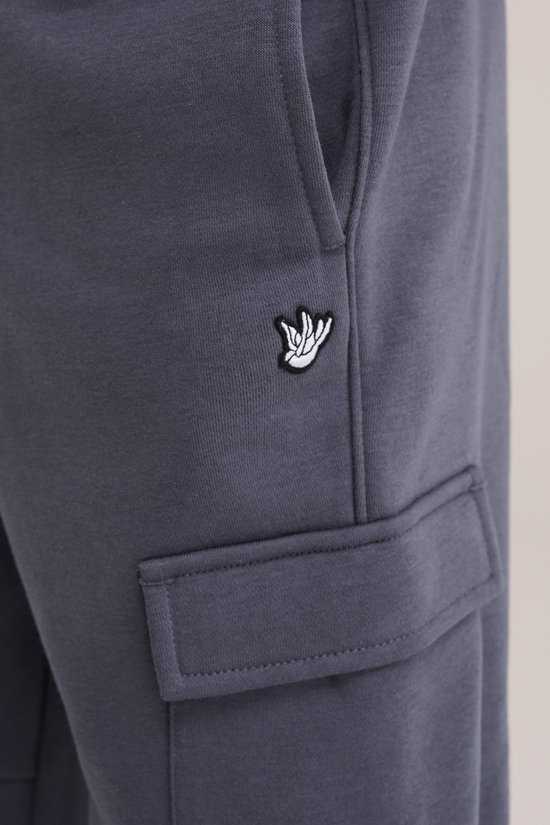 Detail van de donkergrijze cargobroek met geborduurd logo op de zak.