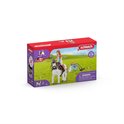 Schleich HORSE CLUB doos met afbeelding van Mia op de witte pony Spotty, een konijn, een cavia, een krukje en een verrekijker op een groene weide.