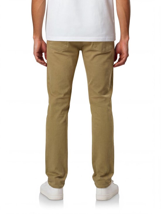 Man met de rug naar de camera, draagt een beige spijkerbroek en witte sneakers.