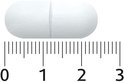 Eén witte capsule met een deelstreep, gemeten op een liniaal van 0 tot 3 cm.
