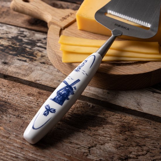 Close-up van de kaasschaaf met Delftsblauwe molen op het handvat.