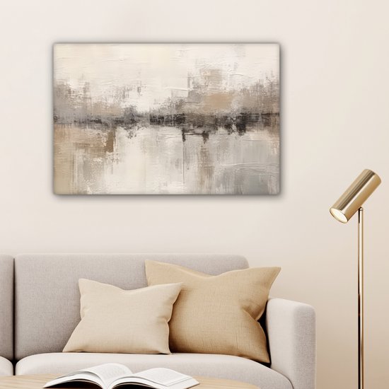 Tableau abstrait dans des tons beige, gris et brun avec texture visible, accroché au-dessus d'un canapé avec des coussins et une lampe sur pied.
