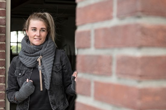 Model met gebreide grijze sjaal en vingerloze handschoenen. Draagt een zwarte spijkerjas.