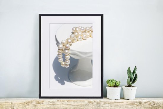 Collier de perles sur socle blanc