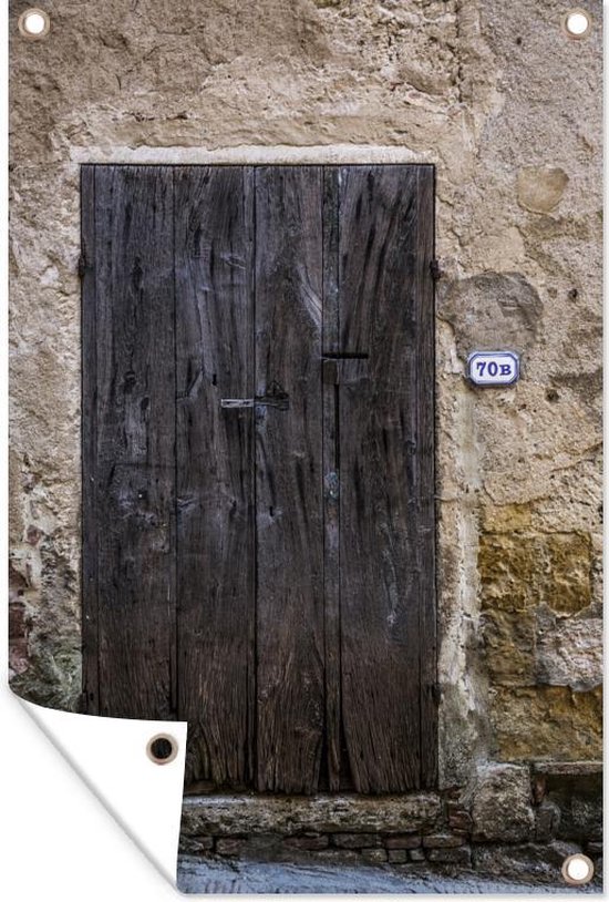 Tuinposter - Een oude houten deur bij een oude muur in het Italiaanse Toscane