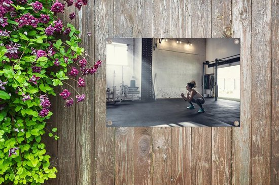 Une femme accroupie dans le gymnase affiche de jardin 60x40 cm - petit - Toile de jardin / Toile d'extérieur / Peintures pour l'extérieur (décoration de jardin)