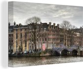 Canvas Schilderij Amsterdamse gracht in de winter - 60x40 cm - Wanddecoratie