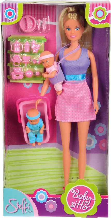 Doos van Steffi Love babysitter pop met roze en paarse kleding. Ze draagt een baby in draagzak en houdt wiegje met baby.