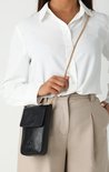 Model draagt een zwarte, verticale lederen tas met gouden schakelketting. Logo met kroon en tekst 'FRED DE LA BRETONIERE'.