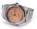Citizen Eco-Drive horloge van zilverkleurig titanium met perzikkleurige wijzerplaat, in de hand gehouden.