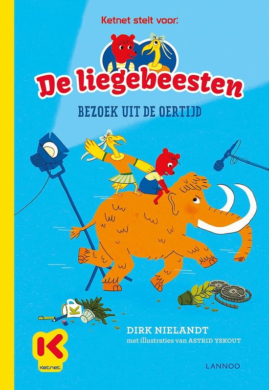 Een bruine beer en een gele kip rijden op een mammoet met slagtanden, op een filmset.
