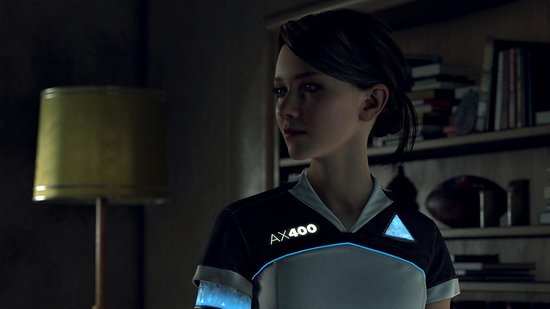 Een jonge vrouw met donker haar, gekleed in een AX400 uniform met blauwe accenten. Ze staat voor een boekenrek.