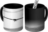 Magische Mok - Foto op Warmte Mok - Een bonte stern vliegt laag over de zee - zwart wit - 350 ML