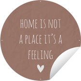Tuincirkel Engelse quote "Home is not a place it's a feeling" met een hartje tegen een bruine achtergrond - 90x90 cm - Ronde Tuinposter - Buiten