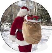 WallCircle - Wandcirkel - Muurcirkel - De kerstman loopt met een zak vol met kerstcadeaus door een bos - Aluminium - Dibond - ⌀ 140 cm - Binnen en Buiten