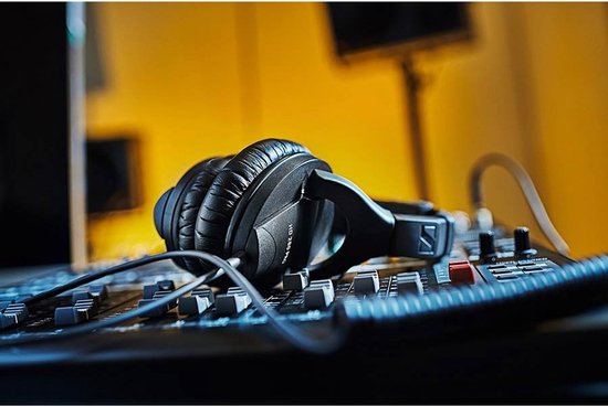 Zwarte Sennheiser HD 280 Pro koptelefoon op een mengpaneel met gele achtergrond.