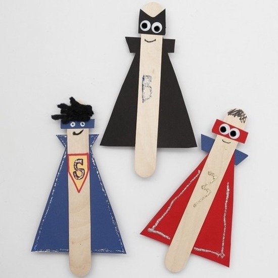 Drie knutsel-superhelden van ijsstokjes met gekleurde capes.