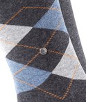 Close-up van donkergrijze sok met ruitpatroon in grijs, blauw en oranje.