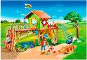 Playmobil speeltuin met groen speelhuis, bruine klimstructuur, glijbaan en schommel.