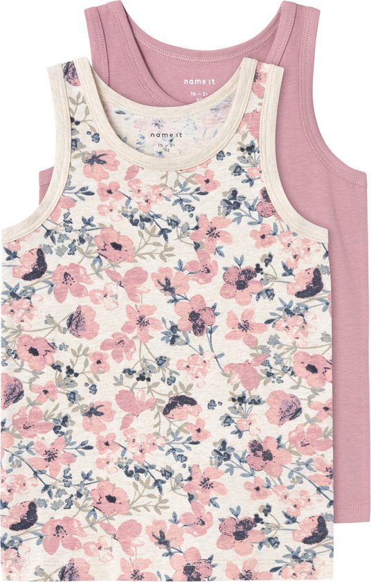 Twee meisjes tanktops op elkaar. Een roze effen, en een met een beige achtergrond en bloemenprint. Maten zichtbaar.