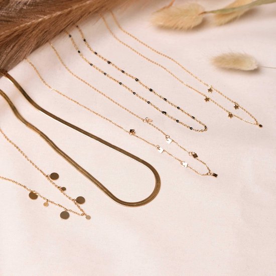 Collectie gouden kettingen met verschillende bedeltjes en kraaltjes.