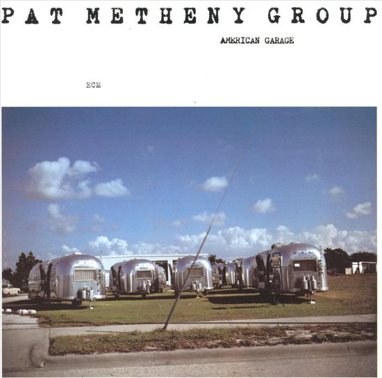 Pat Metheny Group, American Garage albumhoes met meerdere zilveren Airstream caravans op een grasveld onder een blauwe lucht.