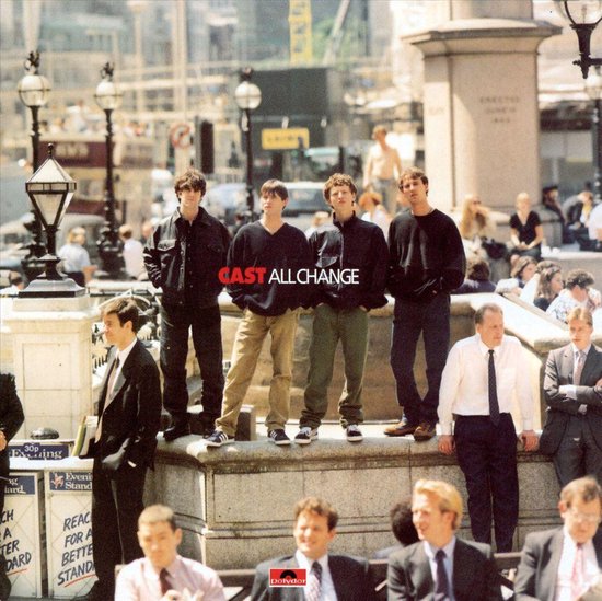 Vier jonge mannen, de band CAST, staan op een stenen muur in een stad, met "CAST ALL CHANGE" erop.