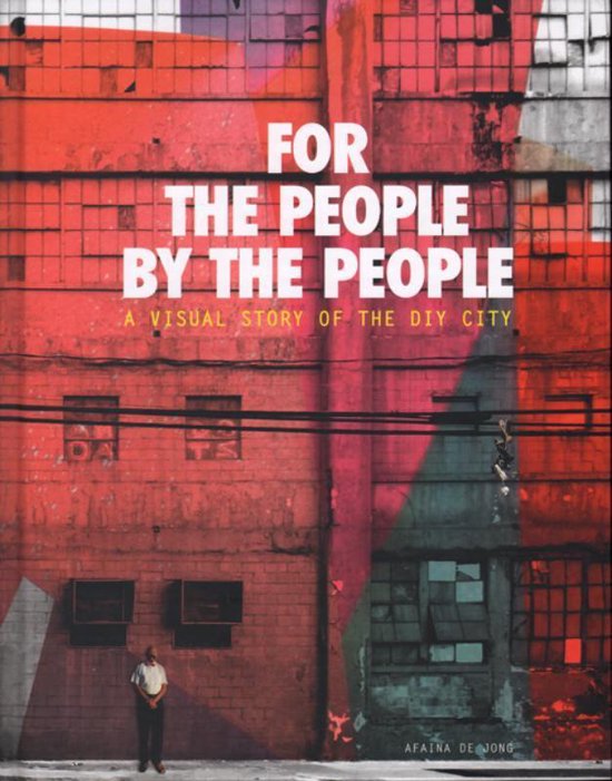 Een man in een licht hemd staat voor een felrode bakstenen muur met de tekst 'FOR THE PEOPLE BY THE PEOPLE'.