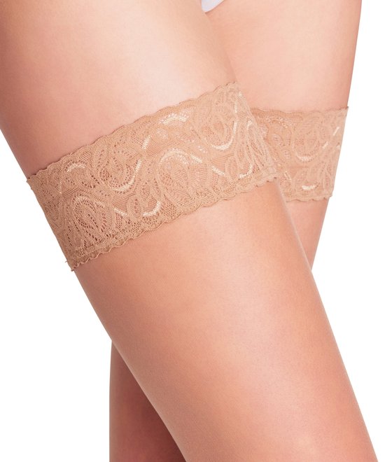 Close-up van de beige kanten boord van stay-up kousen op de dijen van een vrouw.