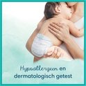 Bébé dort dans les bras d'un parent. Le texte 'I heart you' est sur la couche. Texte 'Hypoallergénique et testé dermatologiquement'.