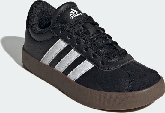 Zwarte kindersneaker van adidas, detail van de voorkant met witte strepen en bruine zool.