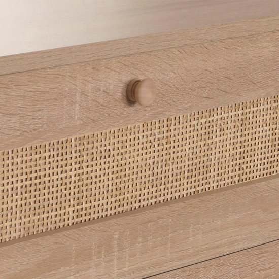 Houten ladekast met een ronde houten knop en een geweven rotan paneel op de ladefront.