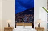 Behang - Fotobehang Luchtfoto van Medellín in Colombia in de nacht - Breedte 120 cm x hoogte 240 cm