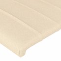 Détail de tissu crème avec coutures verticales sur une tête de lit.