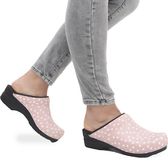 Roze klompen met witte stippen, gedragen met een grijze jeans.