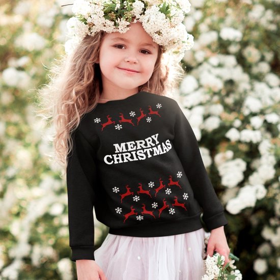 Zwart kindersweatshirt met kerstprint: rode rendieren en sneeuwvlokken, tekst 'MERRY CHRISTMAS'. Meisje draagt het met bloemenkrans.