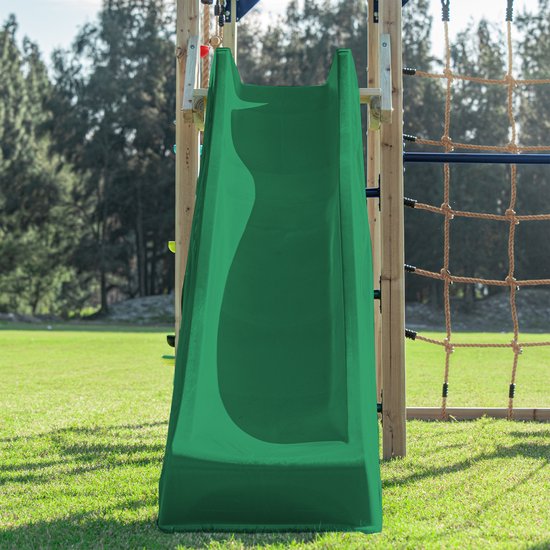 Groene glijbaan van een houten klimtoestel, met op de achtergrond groen gebladerte.
