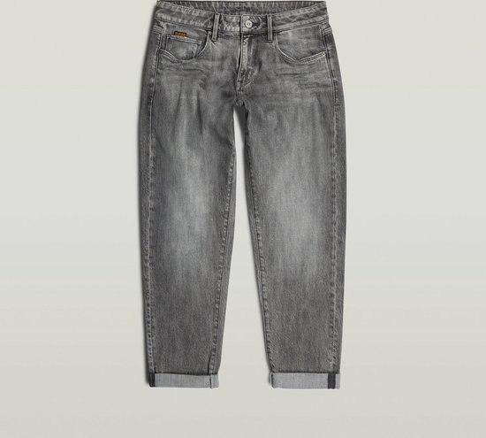 Grijze G-Star jeans met opgerolde broekspijpen, hangend aan een kledinghanger.
