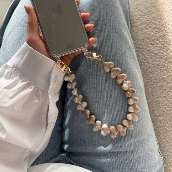 Gedetailleerde weergave van een champagnekleurig telefoonkoord met hartjesparels, bevestigd aan een telefoonhoesje.