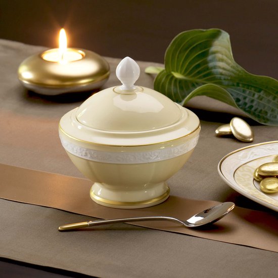 Sucrier crème avec couvercle blanc, accents dorés et bande en relief.