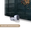 Close-up van de zilveren ophangingsbevestiging aan de zijkant van een glazen wanddecoratie met kruiden.