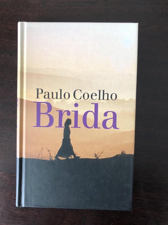 Boekomslag van "Brida" door Paulo Coelho, met een silhouet van een vrouw tegen een zonsondergang.