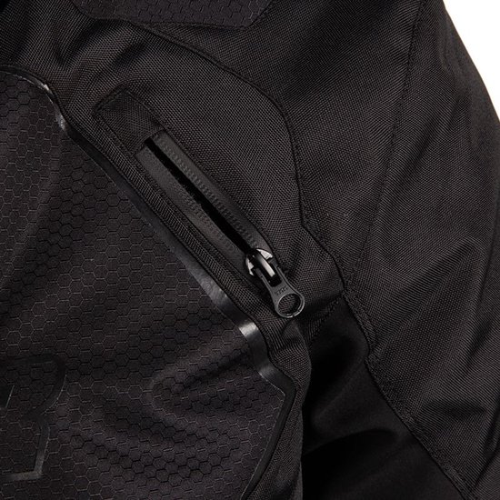 Detail van de rits van een zwarte motorjas met een subtiel hexagon-patroon en glimmende biezen.