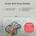 Een hand veegt een raam schoon met een grijze doek. Afmetingen 25x40cm. Tekst: 'Grote Anti-Kras Sticker', 'Gemakkelijk afvegen'.
