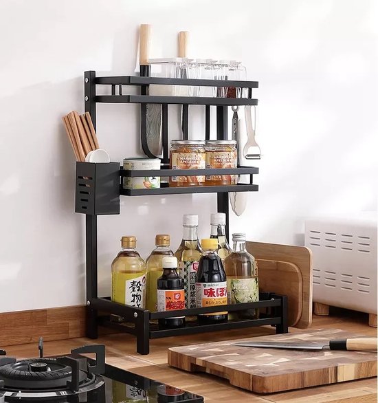 Zwart, tweelaags keukenrek met flessen, potjes, messen en snijplanken.