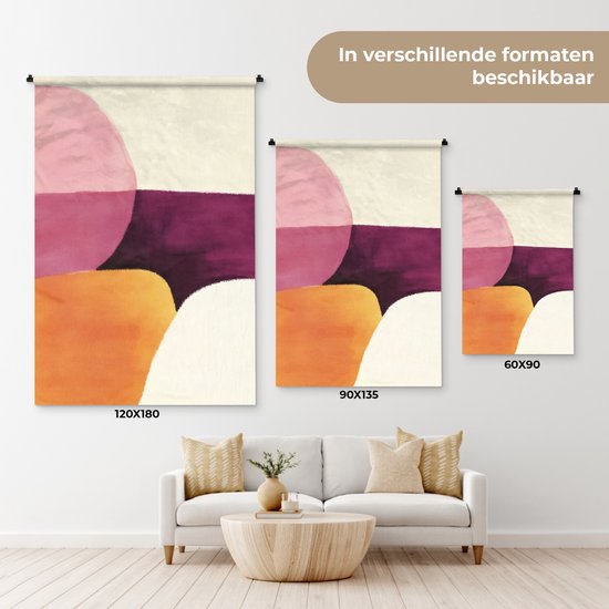 Trois tailles d'une tapisserie abstraite avec des formes roses, violettes, oranges et crème, à côté d'un canapé blanc.