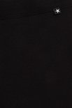 Detail van een zwarte legging met een klein wit sterretje op een zwart label bij de tailleband.