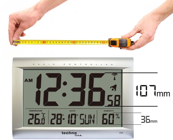 Zilverkleurige radio-gestuurde klok met grote zwarte cijfers, 107mm hoog en 36mm diep. Toont tijd, datum, temperatuur (26.0 C) en luchtvochtigheid (60%).