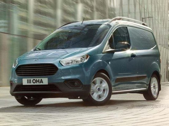 Fourgonnette Ford Transit Courier turquoise roulant dans la rue. plaque d'immatriculation III OHA.