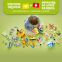 Kind bouwt LEGO Duplo treinset met rails, locomotief, wagonnen en figuren.